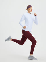 Woman running in white mock neck skiing fleece pullover base layer. #color_White