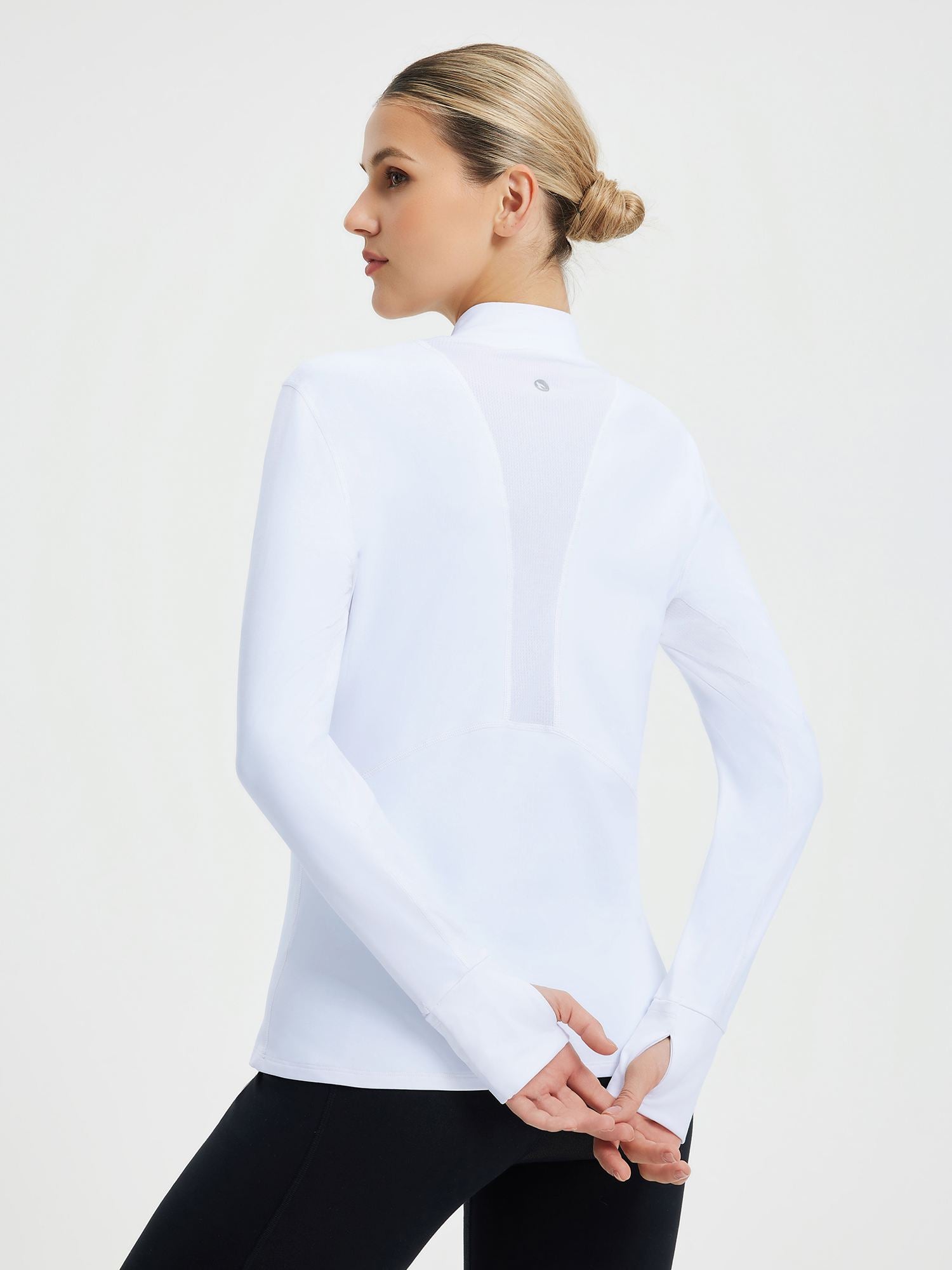 White women's fleece skiing pullover base layer with mock neck and thumb holes. #color_White