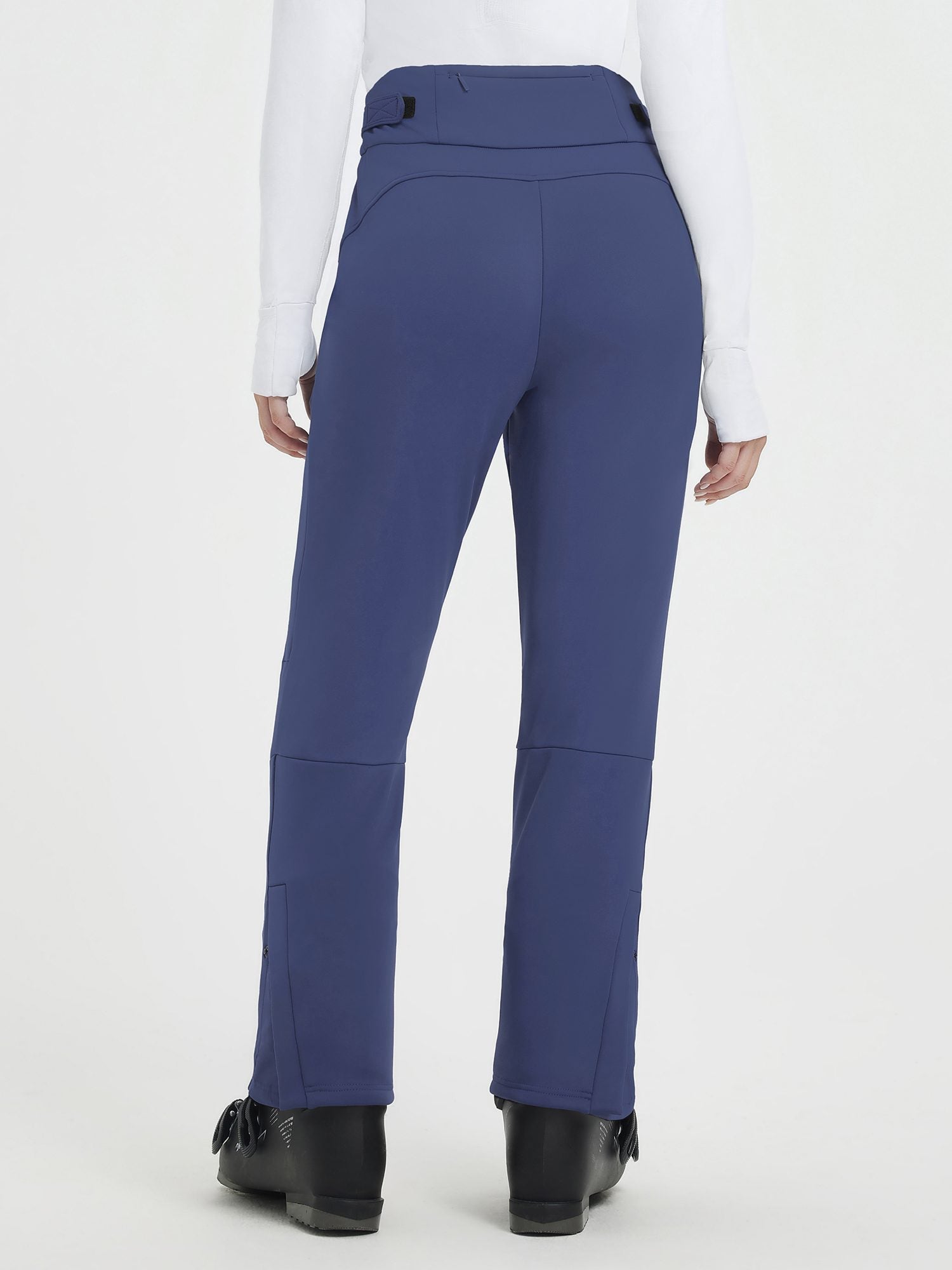 Back view of blue heavyweight knit fleece straight ski pants with articulated knees and ski boots. #color_Navy Blue