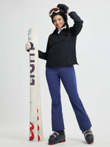 Women's blue softshell ski pants with a slightly flared leg, holding snowboard. #color_Navy Blue