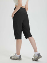 Woman wearing black 15" hiking shorts with multiple pockets and athletic shoes. #color_Black