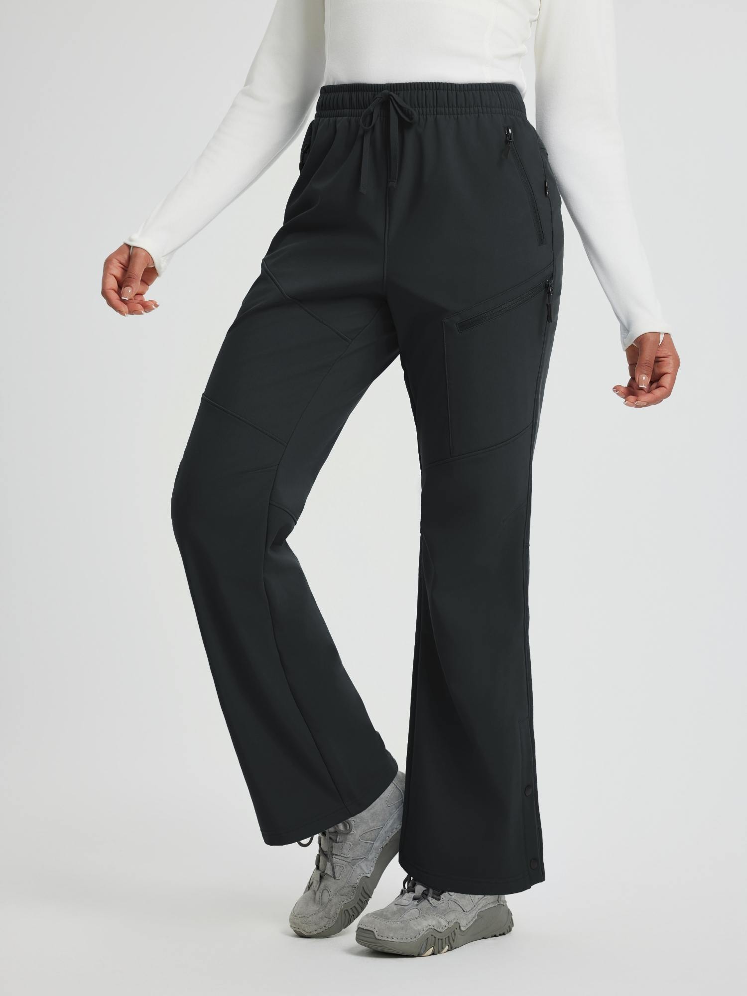 Women's black softshell straight-leg outdoor pants with 3 zipper pockets. #color_Black
