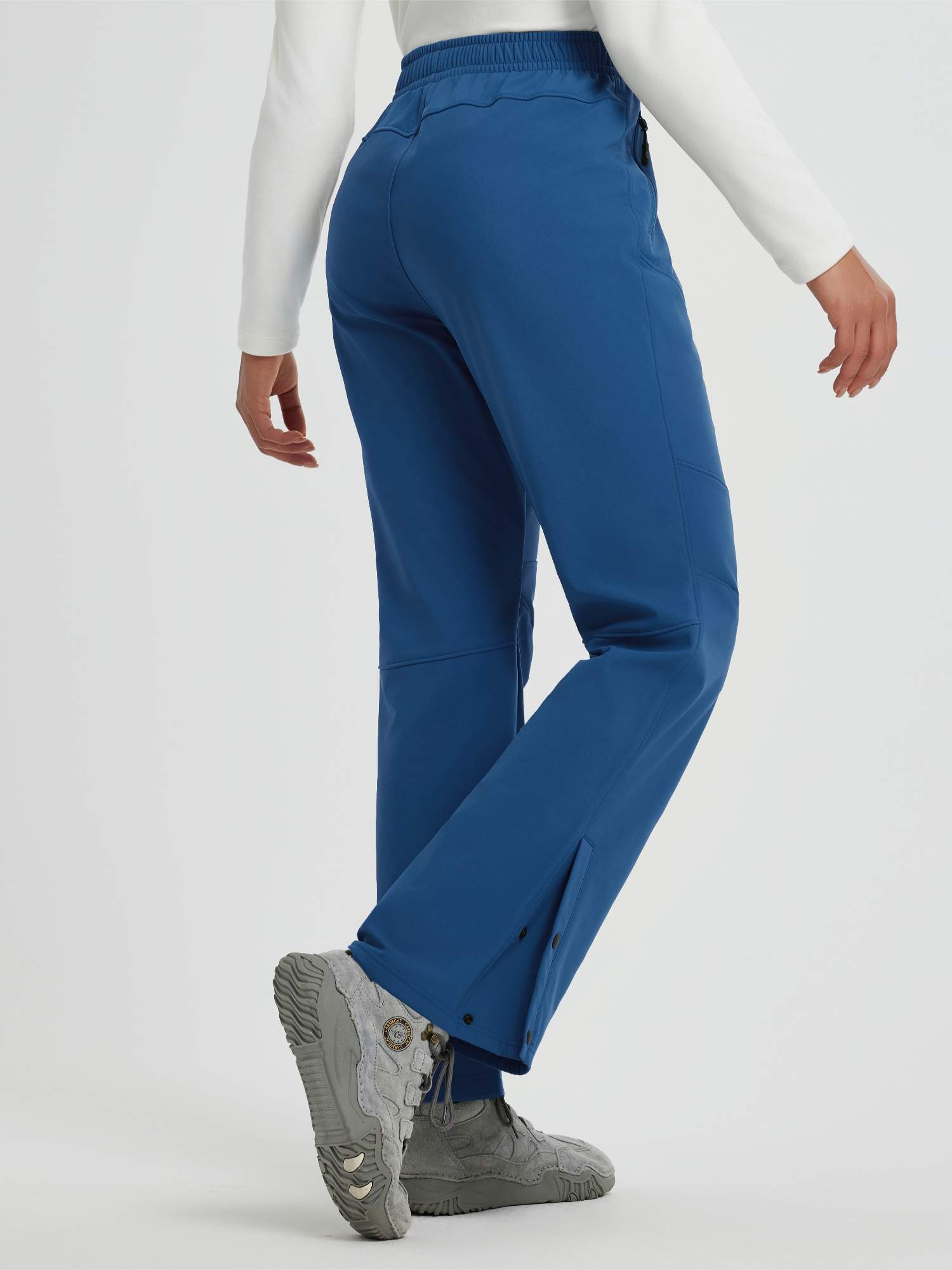 Women's blue softshell straight-leg outdoor pants with zipper pockets and snap closures. #color_Cobalt Blue