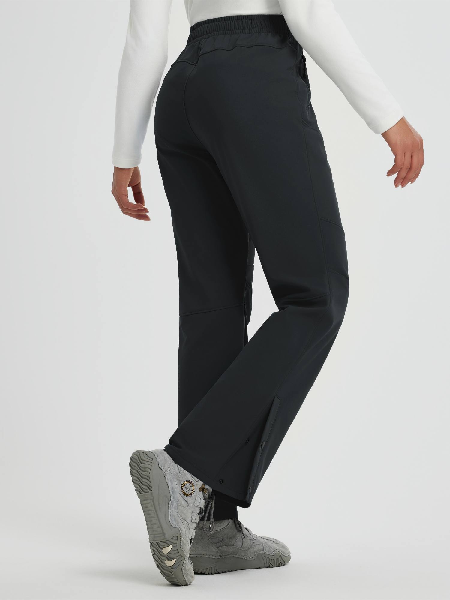 Women's outdoor softshell straight-leg zipper pocket pants with snap closures. #color_Black