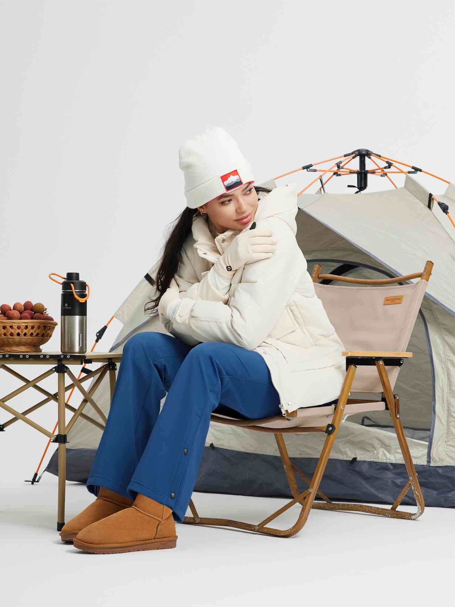 Women's blue straight-leg softshell outdoor pants with zipper pockets and snap details.