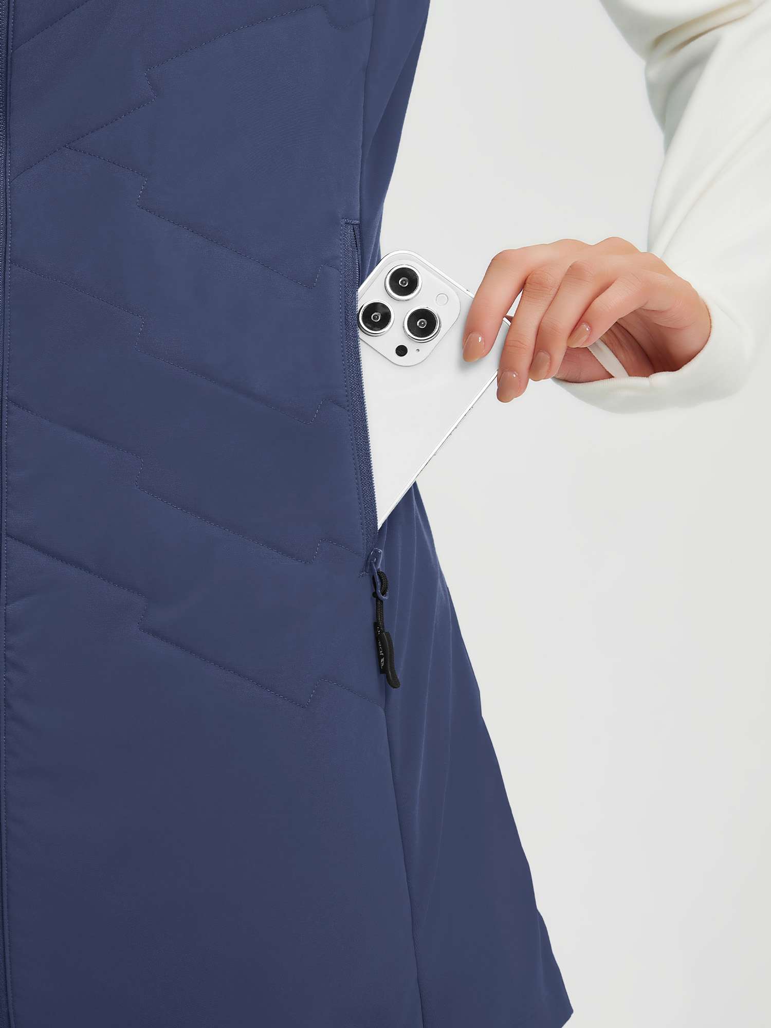 Blue quilted mid-length women's hiking vest with zippered pocket detail. #color_Navy Blue