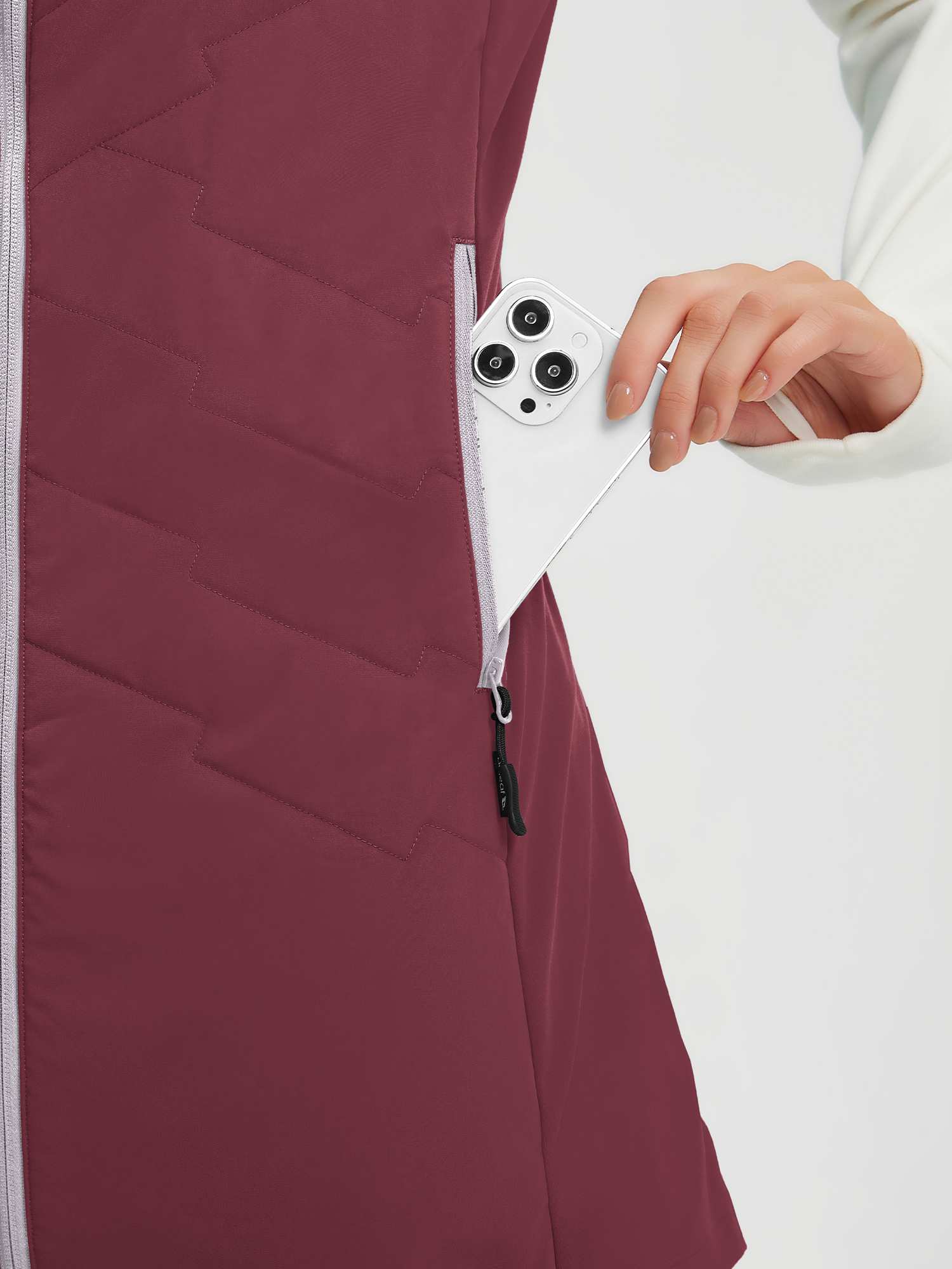 Maroon mid-length women's quilted hiking vest with phone in zippered pocket. #color_Wine Red