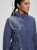 Women's blue cinch waist puffer jacket, showing water-resistant fabric repelling water. #color_Navy Blue
