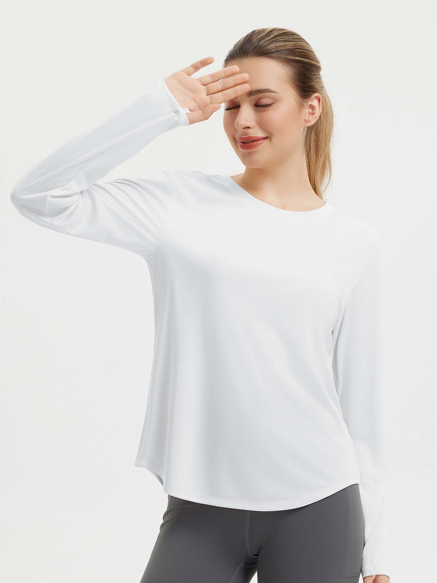 Women's white long sleeve running shirt with thumbholes shielding eyes from sun #color_White