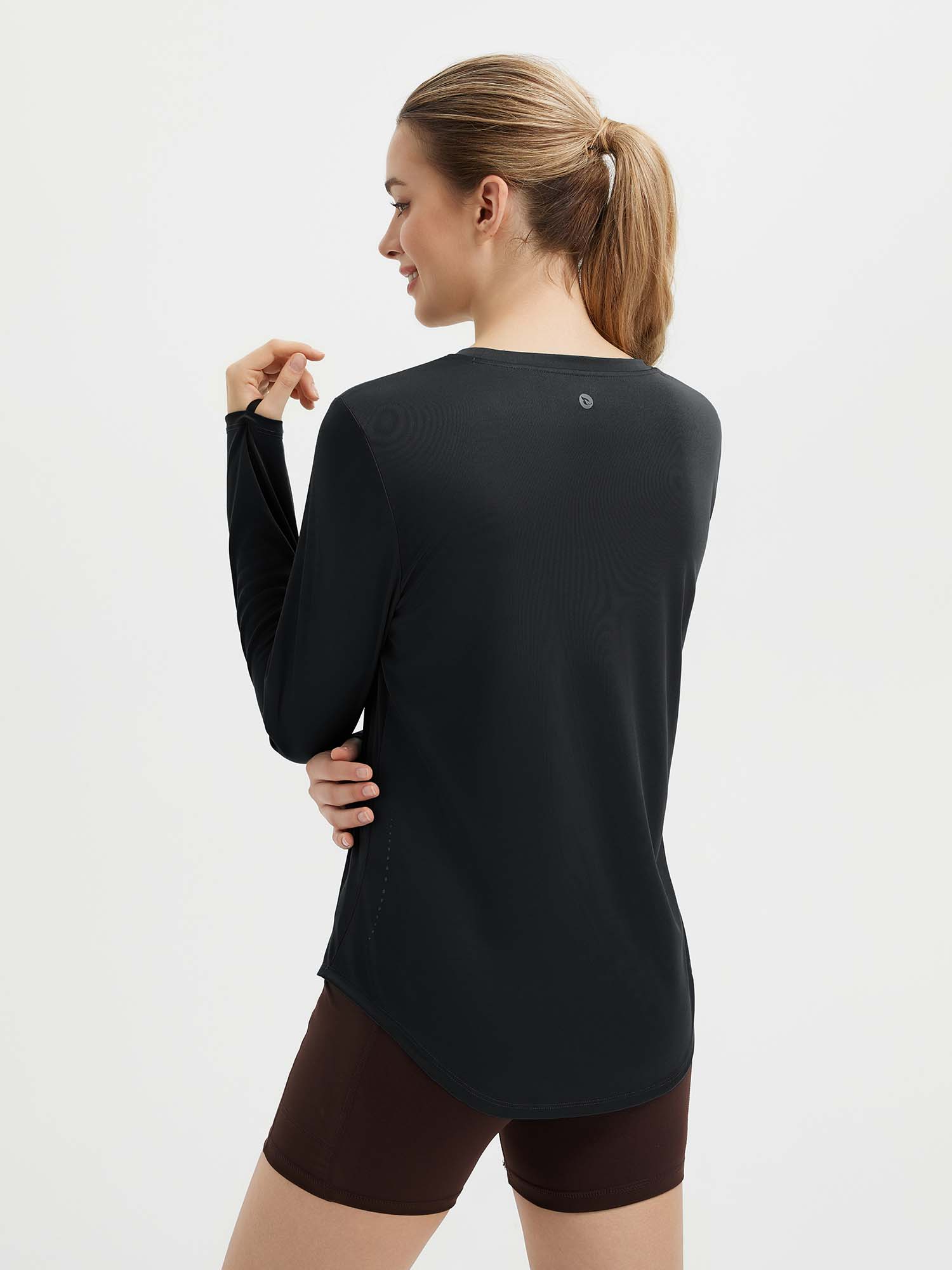 Women's black running shirt: long sleeve, thumbholes, high-low hem, side slits, reflective dots. #color_Black
