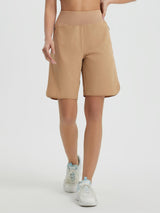 Women's tan 9-inch high-waisted athletic running shorts with curved hem and zipper pockets. #color_Brown