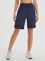 Women's navy blue 9" high-waisted running shorts with loose fit, curved hem, and zip pockets. #color_Navy Blue