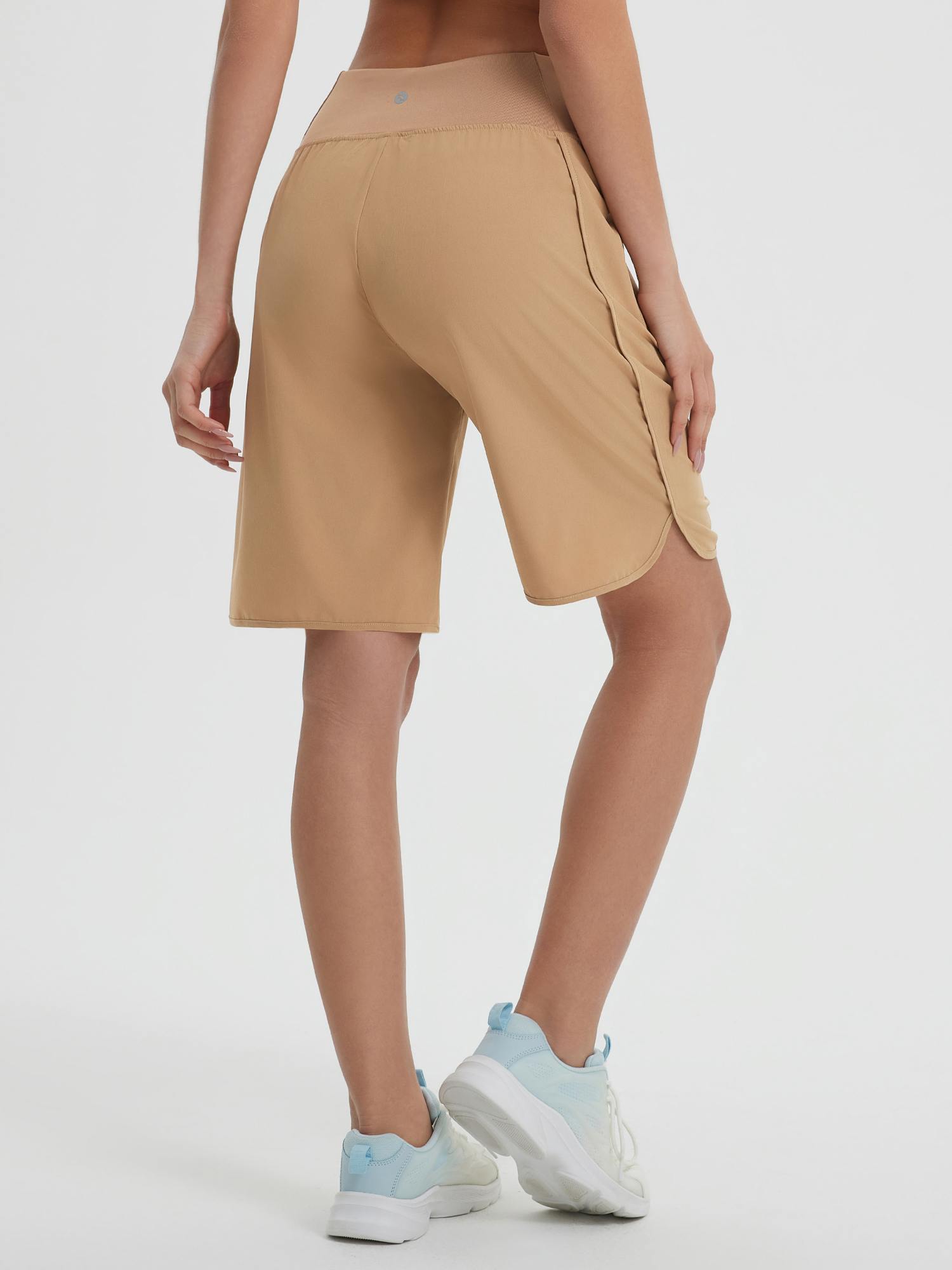 Tan women's 9-inch high-waisted running shorts with loose fit, curved hem, and side zipper pockets. #color_Brown
