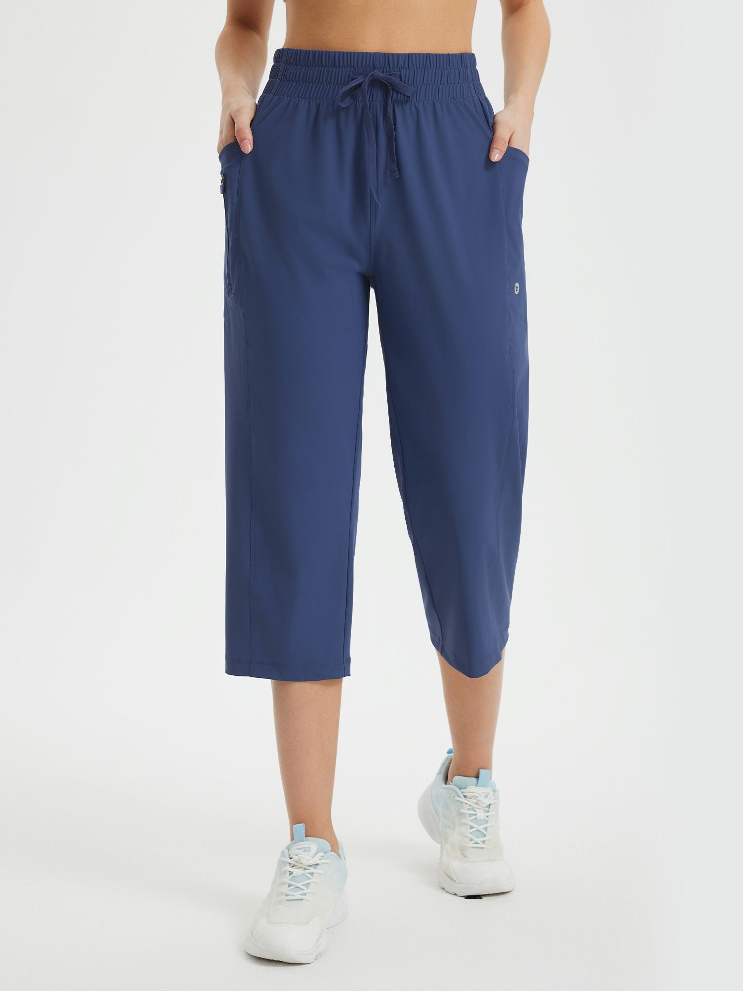 Blue women's athletic capris with loose fit, drawstring waist, and side pockets. #color_Navy Blue