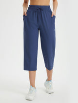 Blue women's athletic capris with loose fit, drawstring waist, and side pockets. #color_Navy Blue
