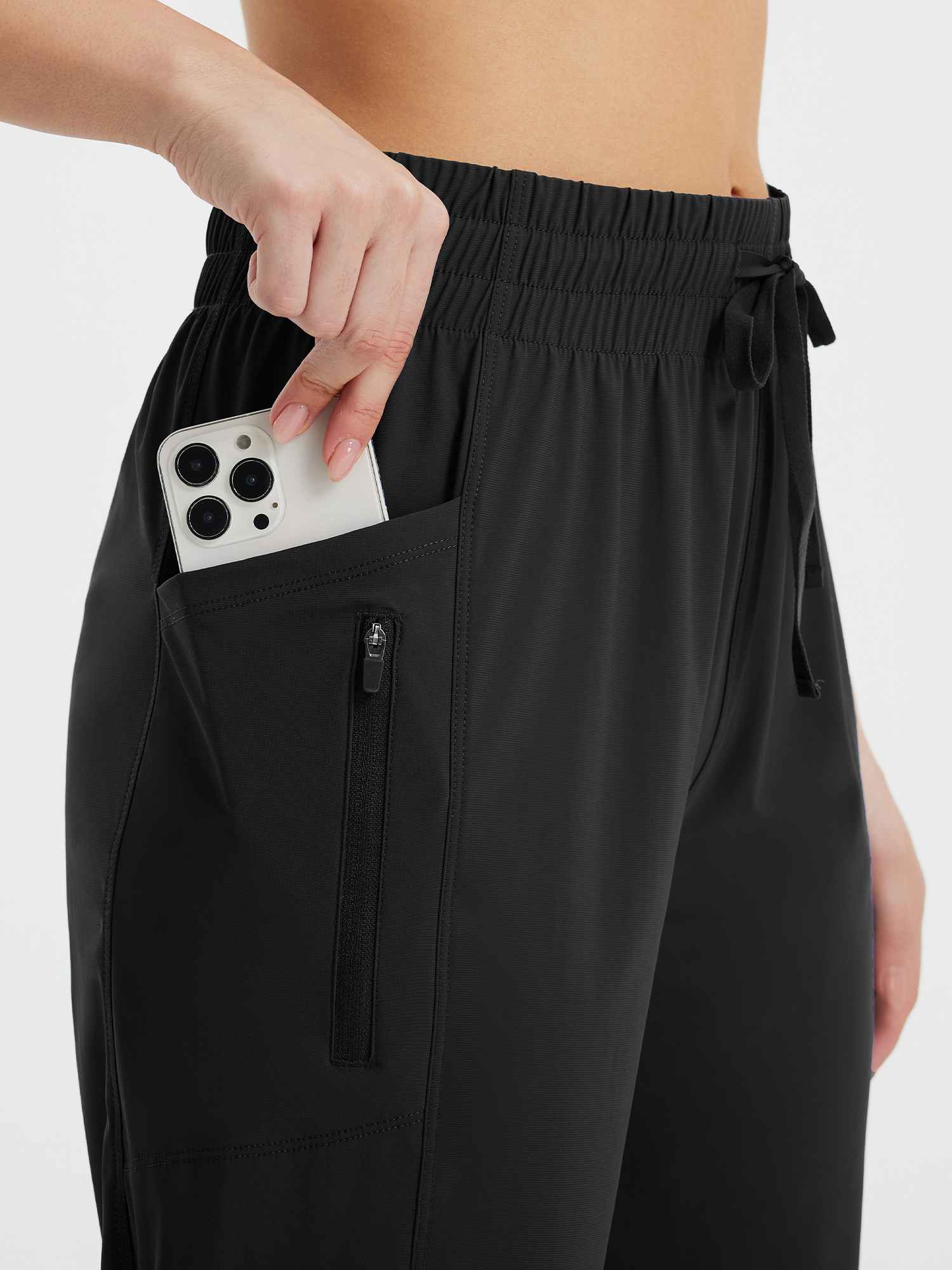 Black women's athletic capris with phone in side pocket and zippered pocket detail. #color_Black