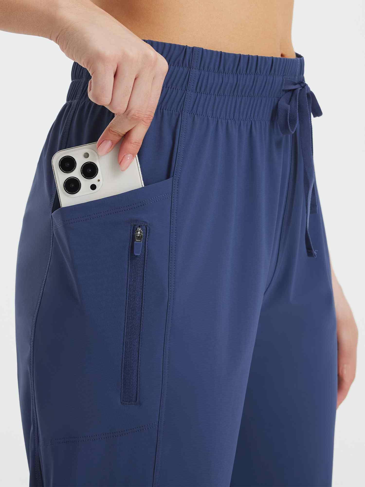 Women's navy athletic capris with drawstring waist, side pocket and zippered phone pocket #color_Navy Blue