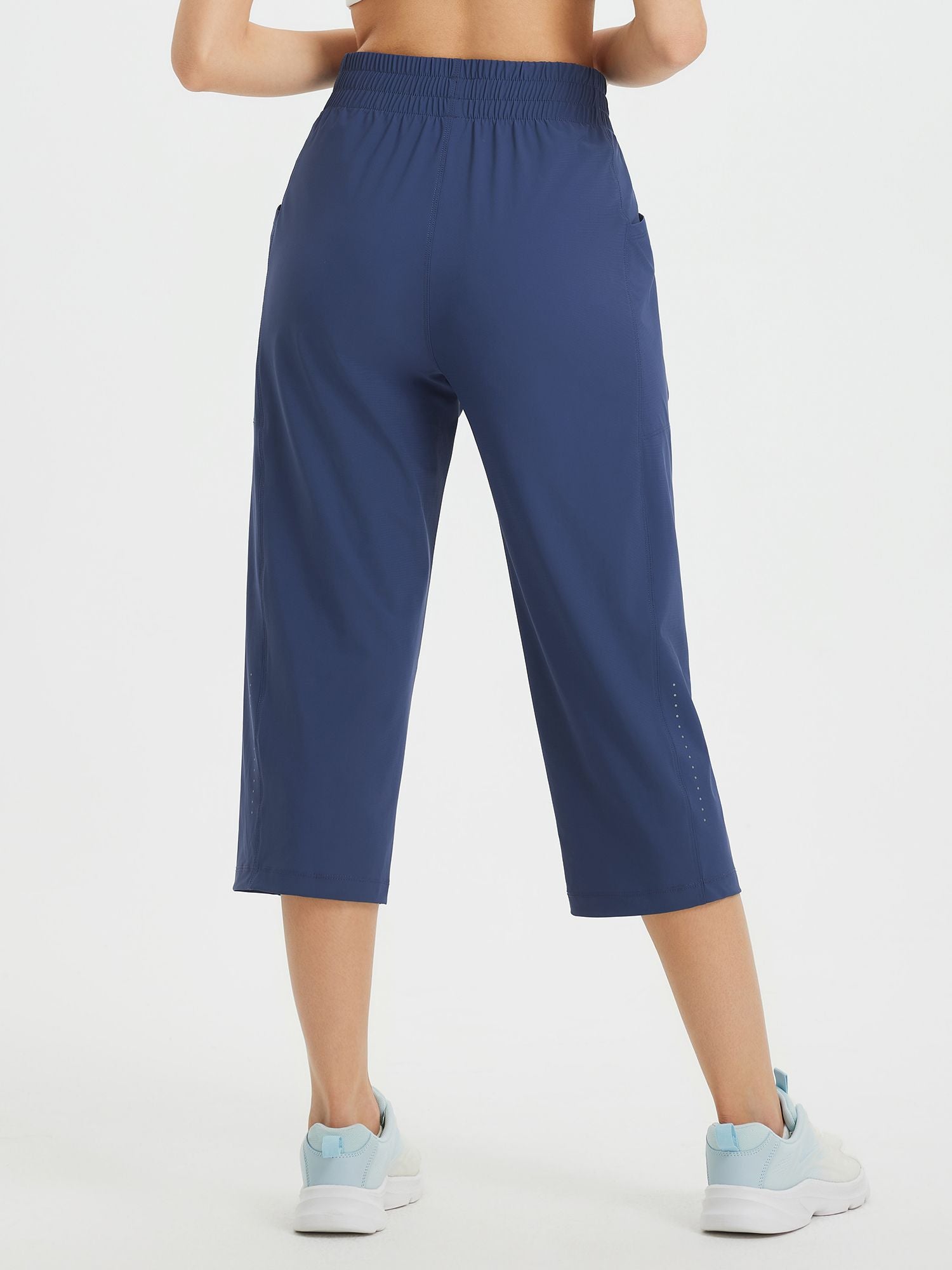 Women's navy blue athletic capris with loose fit, drawstring waist, and pockets.