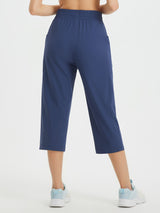 Women's navy blue athletic capris with loose fit, drawstring waist, and pockets.