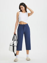 Women's blue athletic capris with loose fit, drawstring waist, and pockets. #color_Navy Blue
