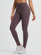High-waisted running fleece leggings in plum with pockets and drawstring.