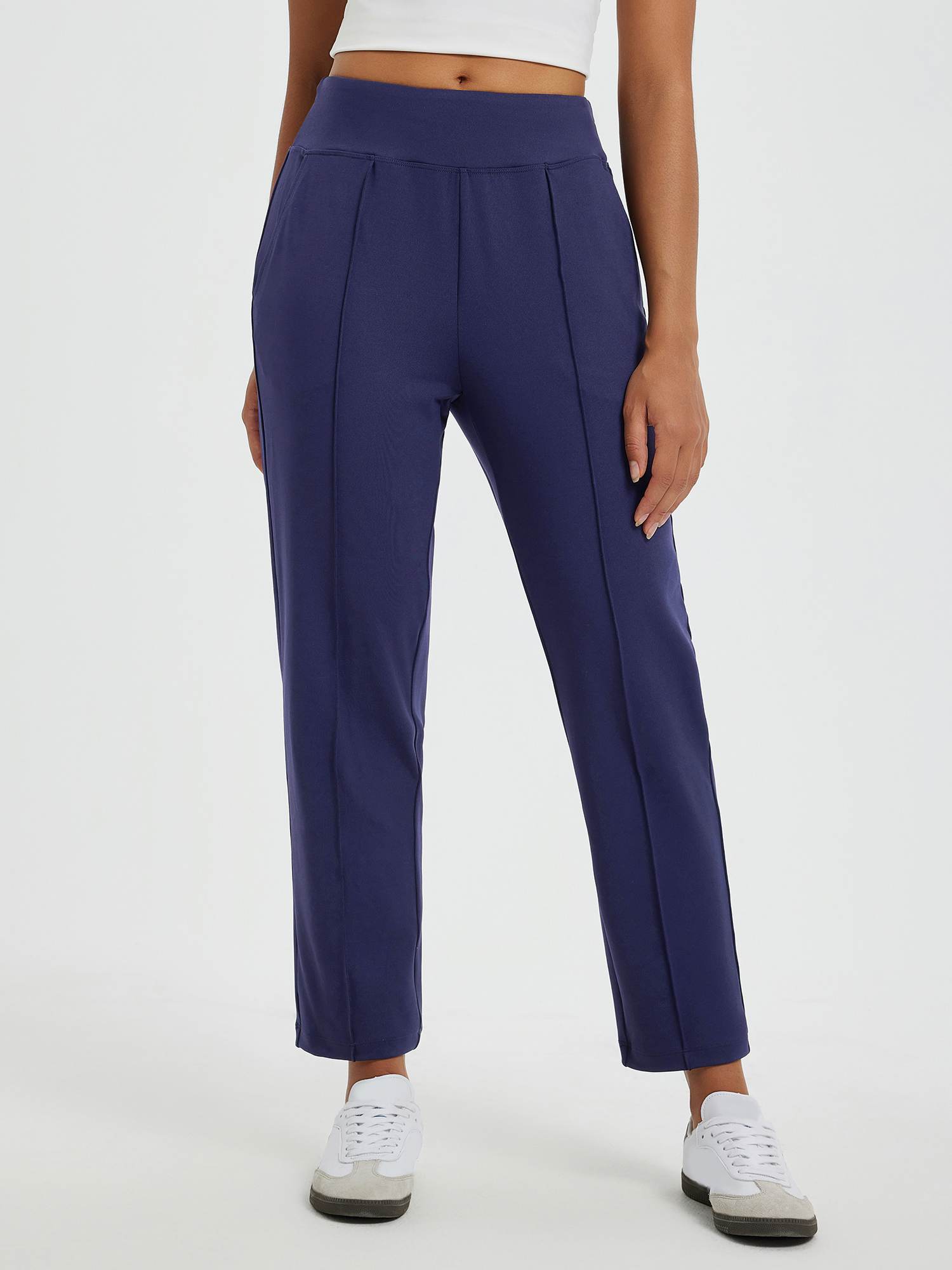 Navy blue tapered running pants with pouch pockets, center seam, ankle length. #color_Navy Blue
