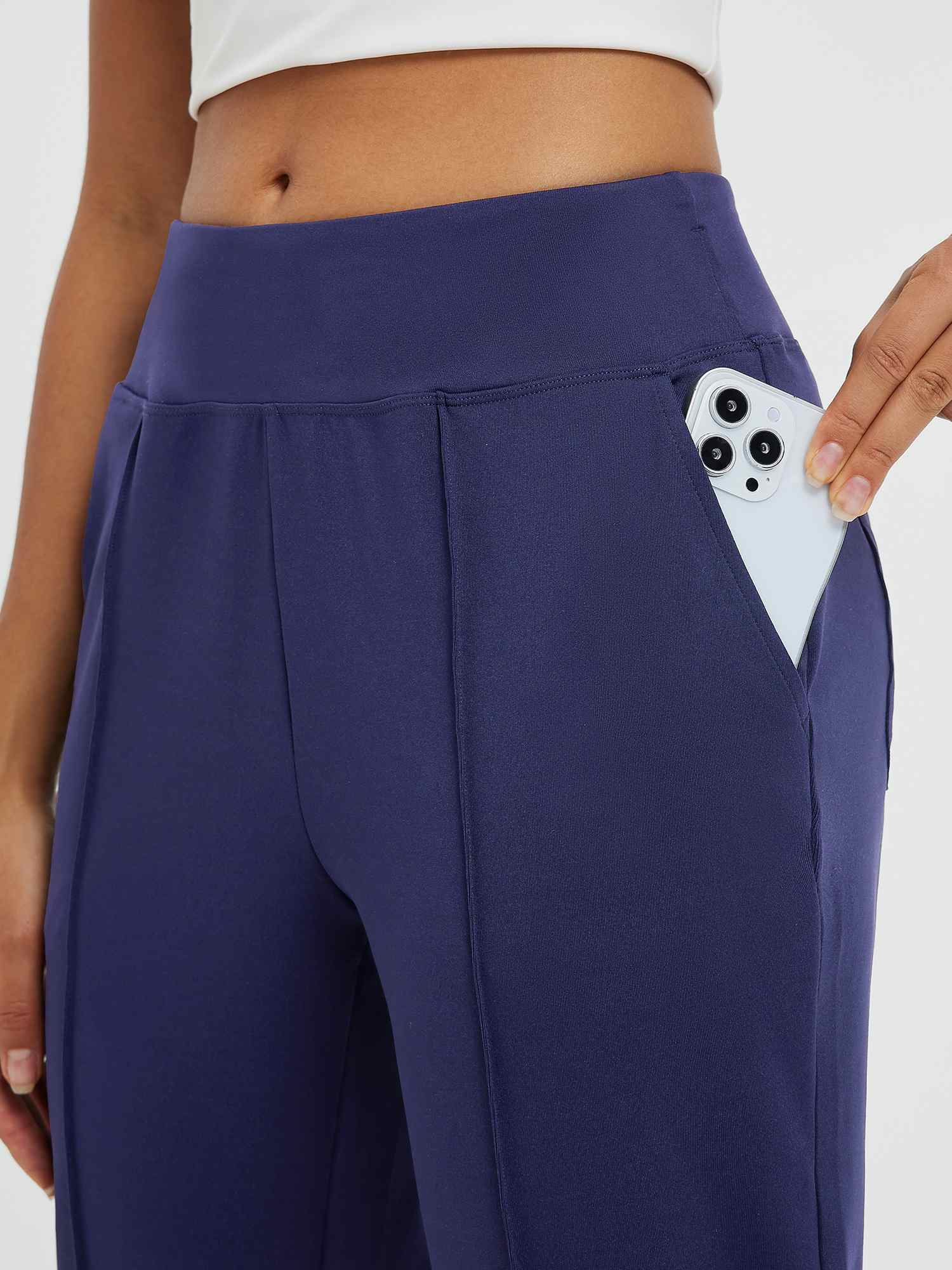 Navy tapered running pants with deep side pocket holding smartphone #color_Navy Blue