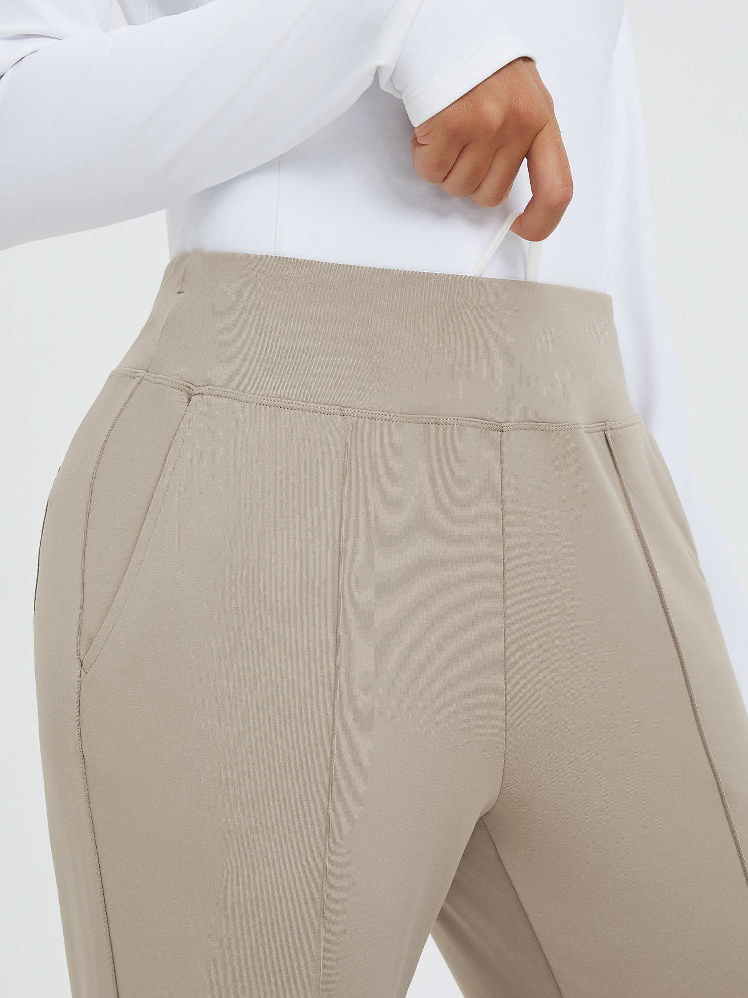 Beige tapered running pants with high waist, drawstring, and deep pouch pockets. #color_Teak Brown