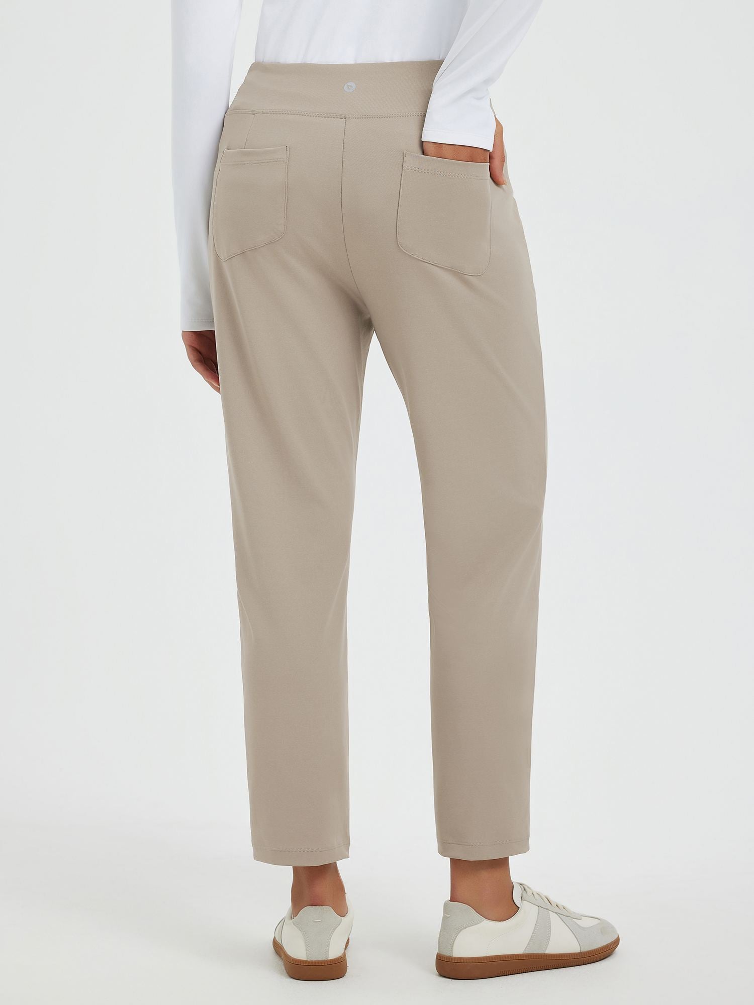 Beige tapered running pants with two back pockets, slim fit, stretch fabric.