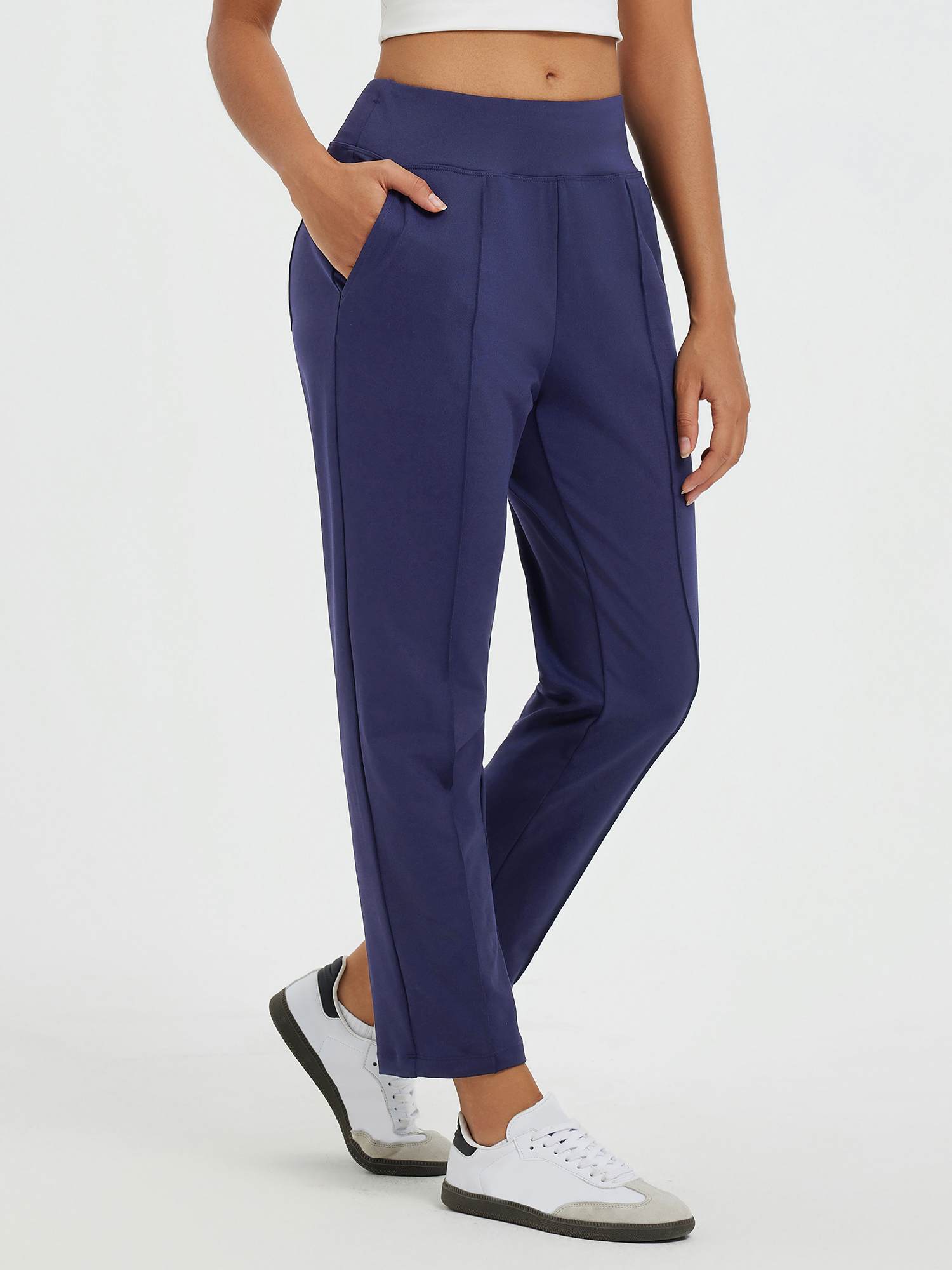 Navy blue tapered running pants with high waist and pouch pockets.