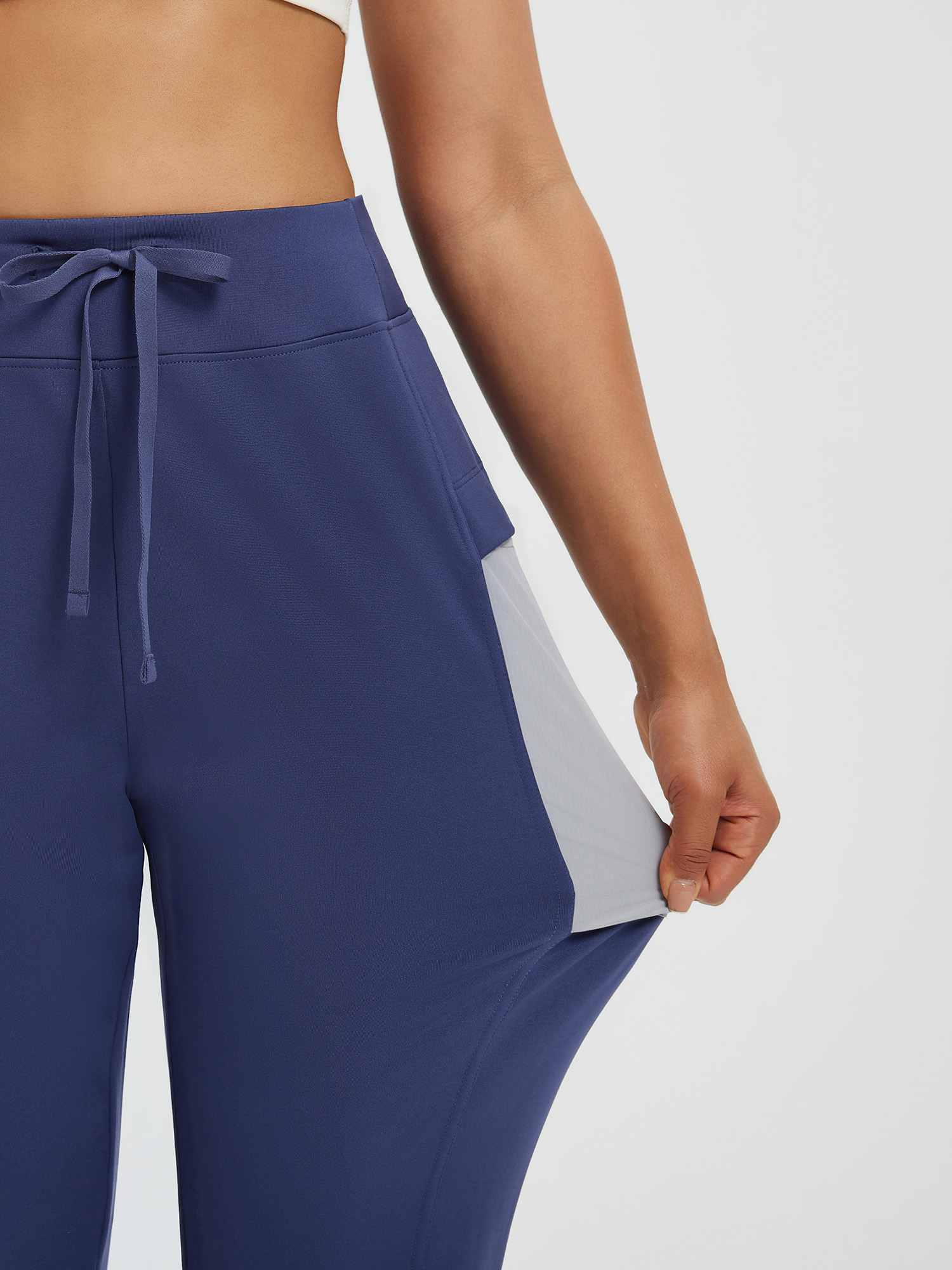 Navy fleece-lined women's running pants with patchwork pockets and drawstring. #color_Navy Blue
