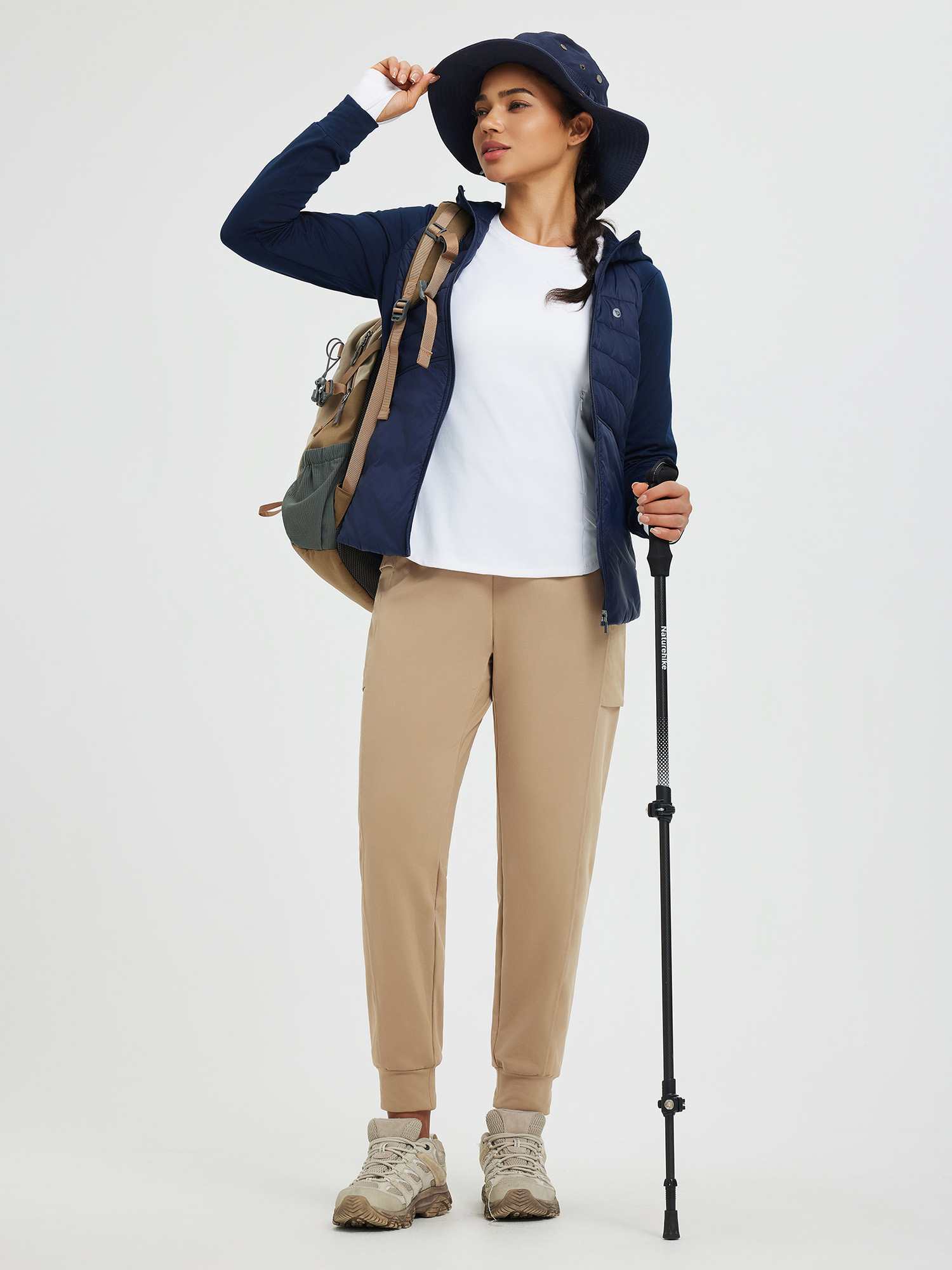 Women's tan fleece cuffed running pants with patchwork pockets, model in outdoor gear. #color_Tea Brown