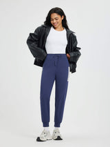 Women's navy fleece-lined running pants with patchwork side pockets and cuffed ankles.