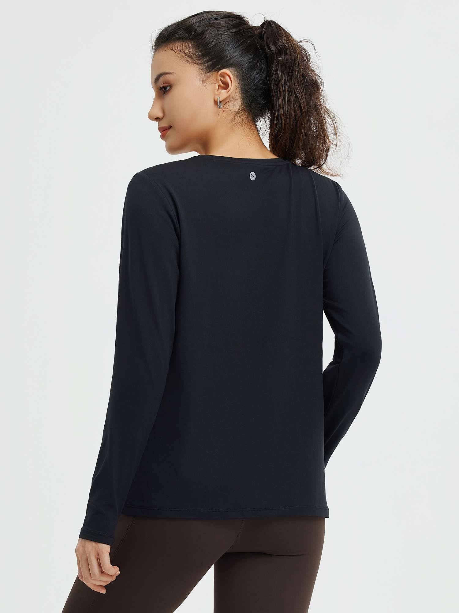 Back view of women's black crewneck long-sleeve running top with small logo #color_Black