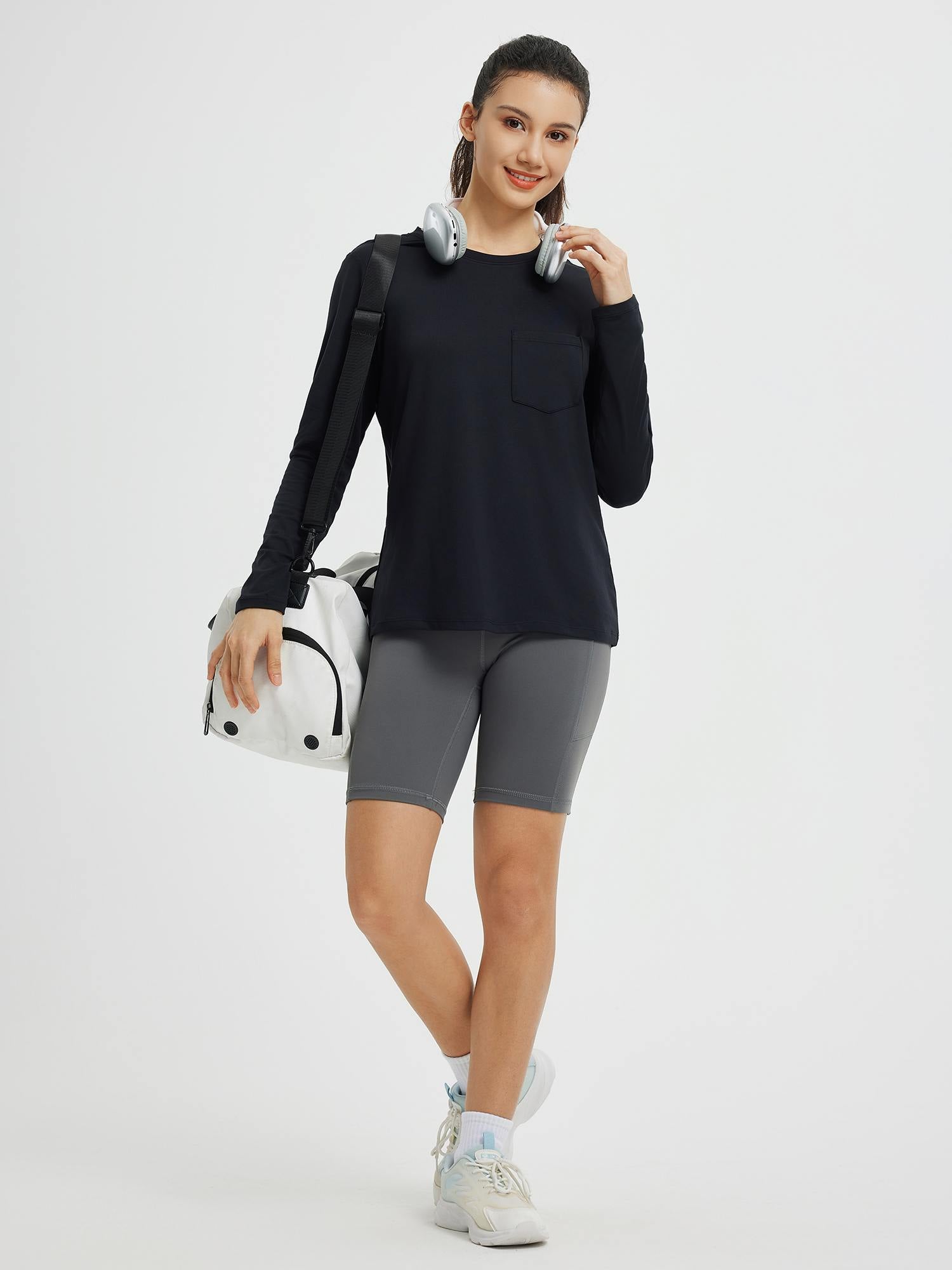Black running crewneck long-sleeve pocket top on model with gym bag #color_Black