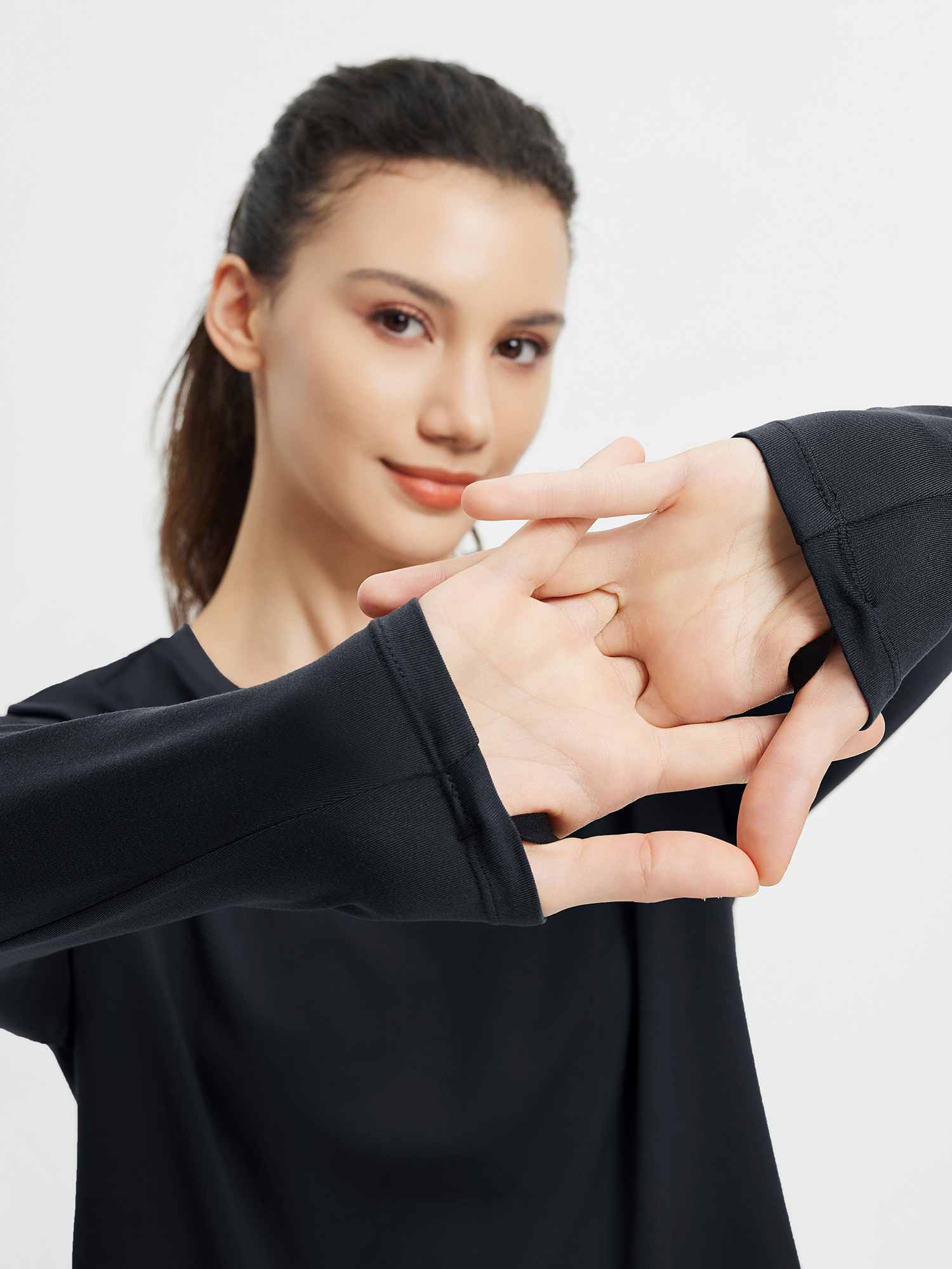 Black long-sleeve running t-shirt with thumb loops and stretch fabric. #color_Black