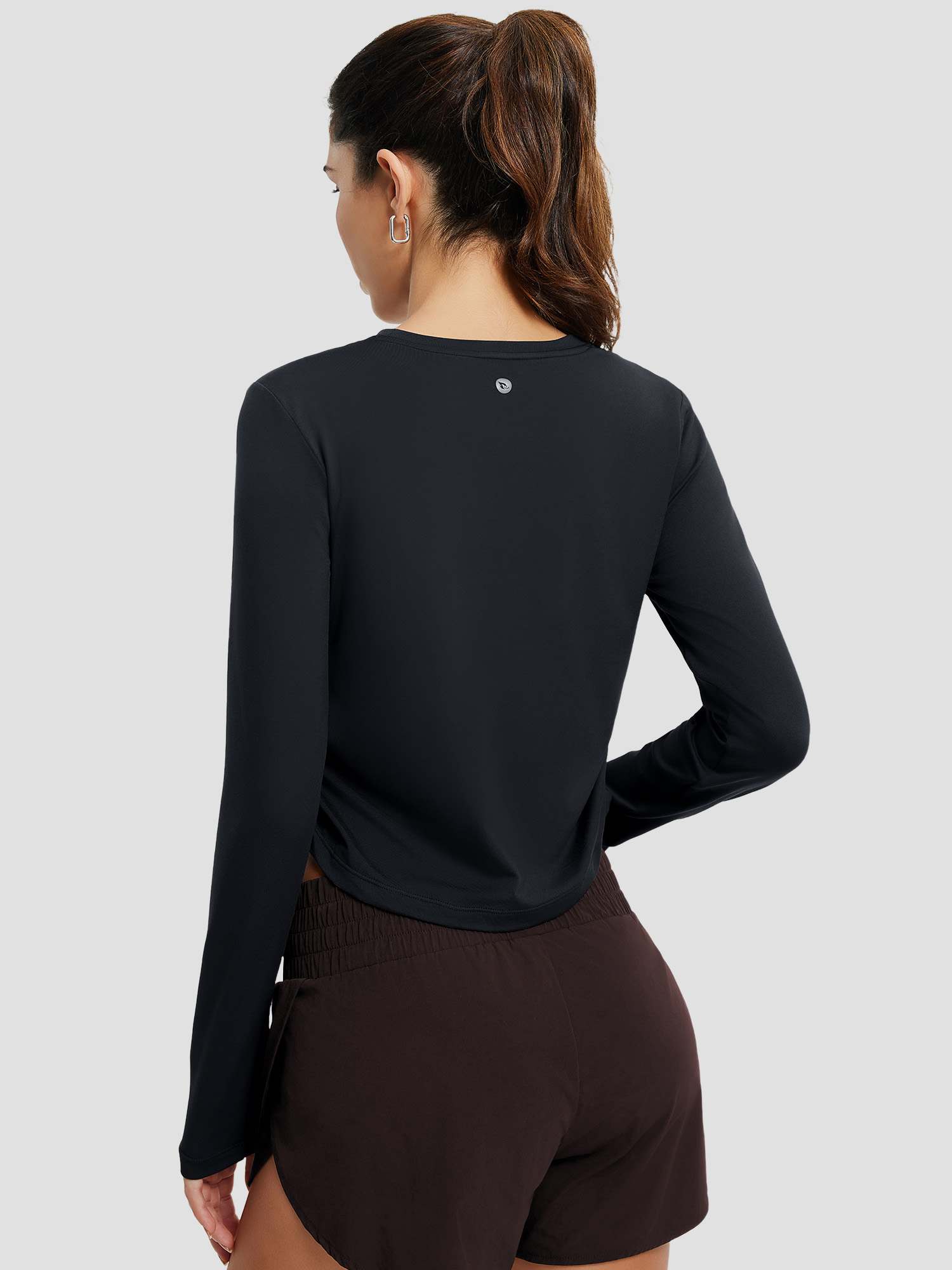 Women's black long-sleeve running t-shirt with ruched side hem, back view.