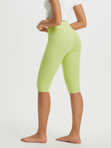 Woman wearing lime green high-waisted crossover capris with side pockets. #color_Light Green