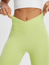 Women's high-waisted crossover capris in light green, showing stretchy fabric and v-cut waistband. #color_Light Green