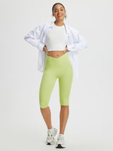 Woman wearing light green 14-inch high-waisted crossover capris, white crop top, and white open shirt. #color_Light Green
