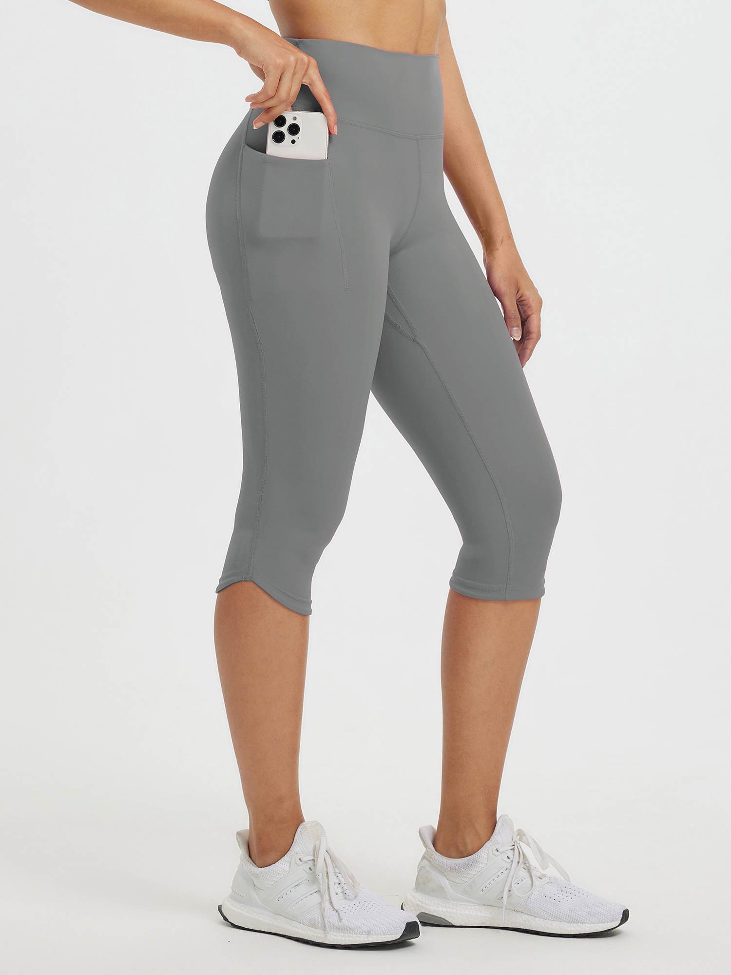 Women's gray high-waisted 17" capris with side pockets holding a phone #color_Dark Gray