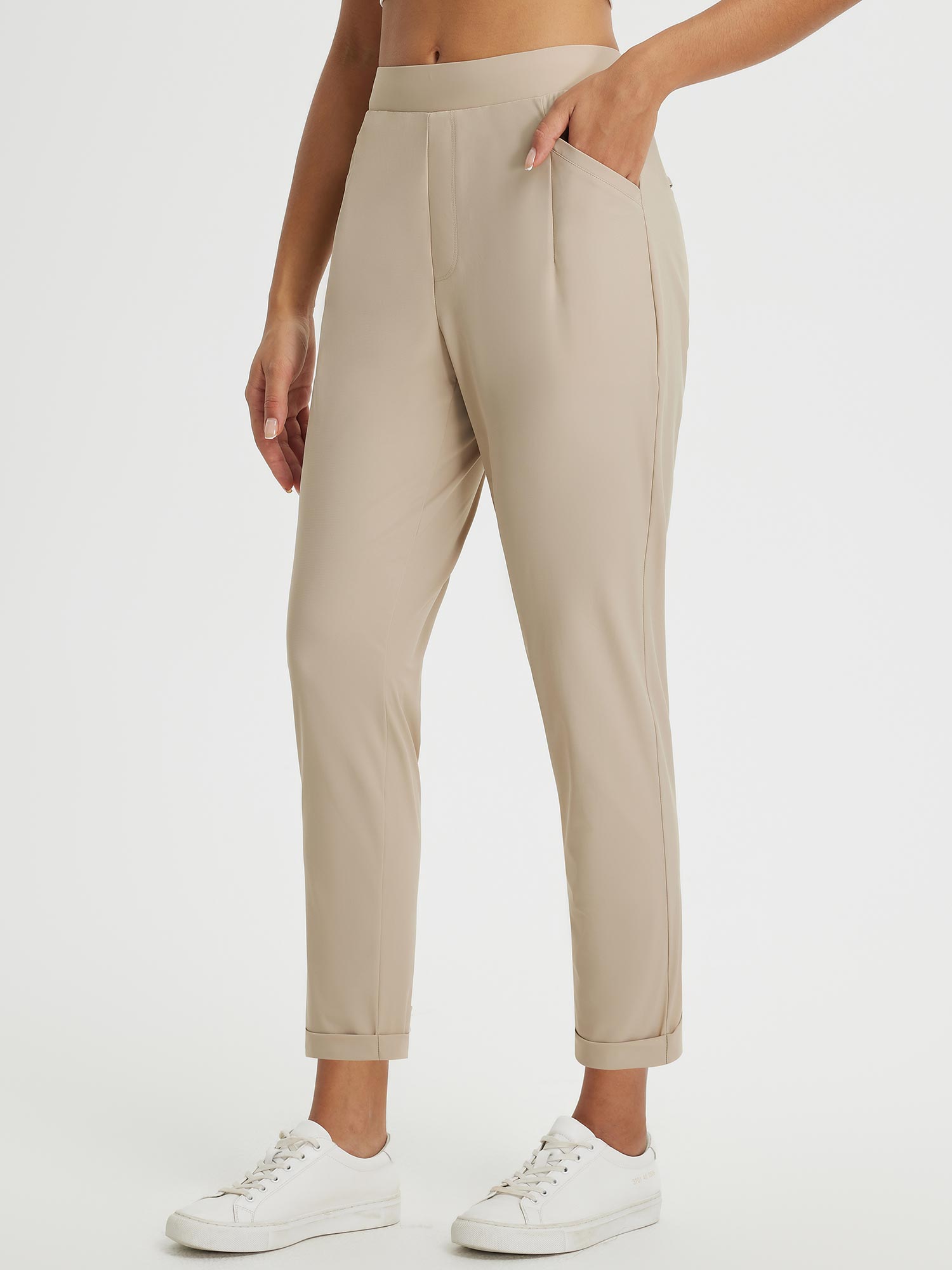 Beige Dynamic Form high-rise tapered trousers with cuffed hem, styled for outdoor travel. #color_Doeskin