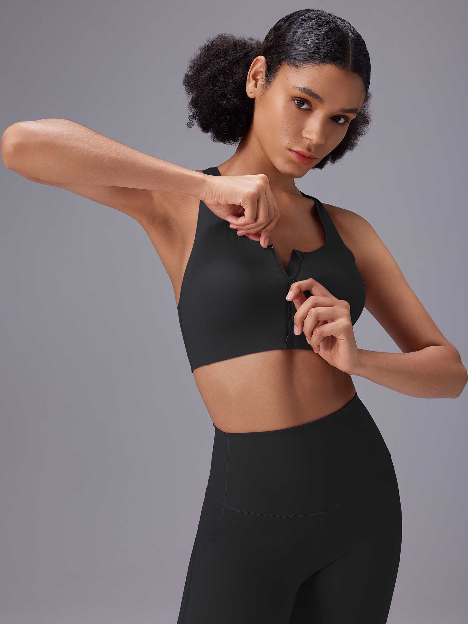 Black front zip sports bra on model, part of high-impact training set. #color_Black