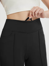 Close-up of black women's high-waisted capris with a hand reaching for the internal drawstring. #color_Black