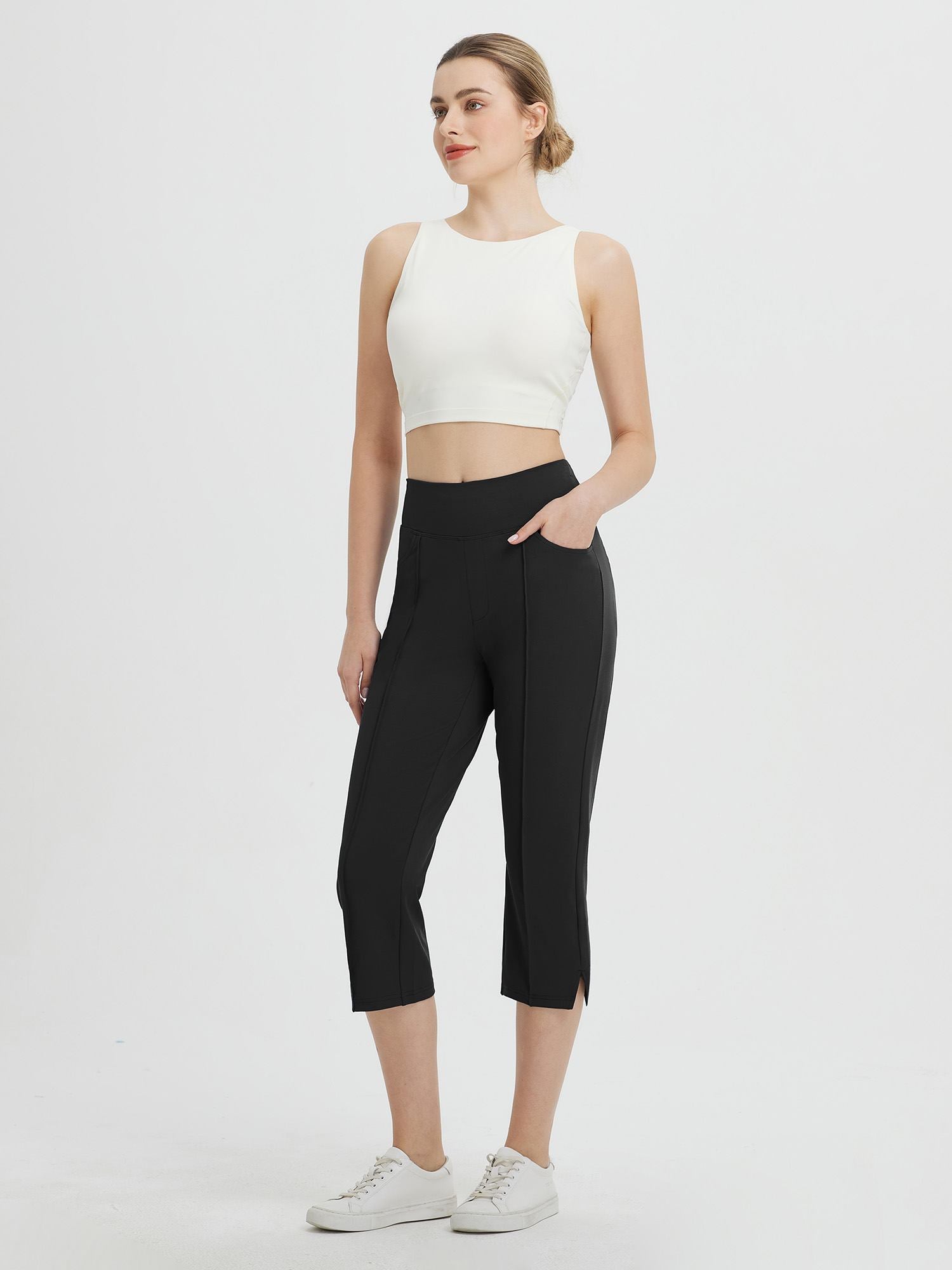 Woman wearing black Baleaf high-waisted capris with side pockets and white sneakers. #color_Black