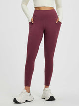 Women's heathered burgundy fleece-lined yoga leggings with high-rise tummy control waistband and pockets.