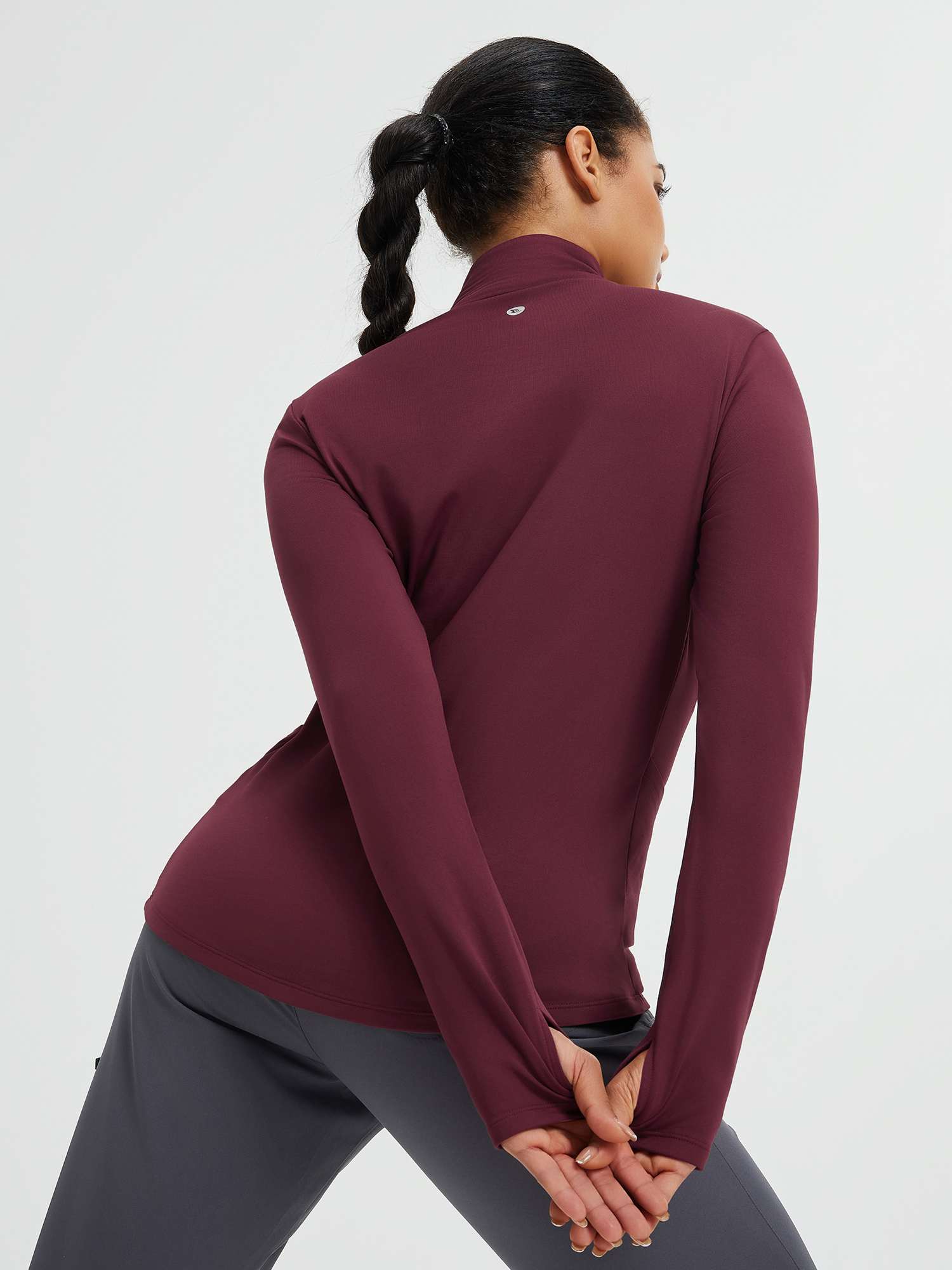 Back view of women's burgundy long-sleeve yoga top with thumbholes #color_Wine Red