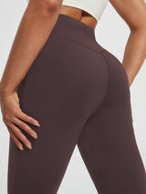 Women's cuffed high-waisted fleece yoga leggings in deep brown with side pockets. #color_Dark Brown