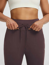 Women's plum fleece-lined yoga leggings, high-waisted with drawstring and side pockets. #color_Dark Brown
