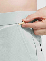 Baleaf light green 7" golf shorts, hand placing golf tee in waistband detail. #color_Light Gray